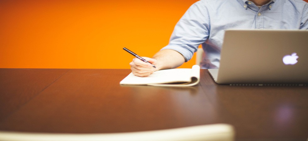 Working through a business plan with a notebook and laptop